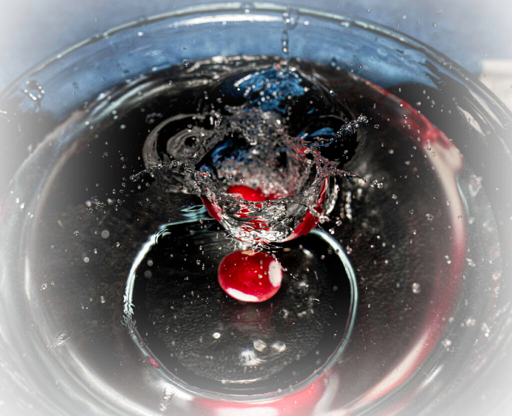 Red radish plunging through swirling water vortex high speed photography fine art by Hadi Baradaran ArtQuestor