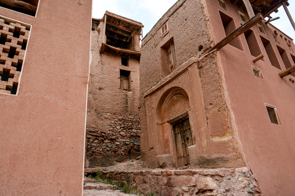Abyaneh Iran narrow alley ancient pink red mud brick buildings Persian mountain village fine art photography by Hadi Baradaran ArtQuestor