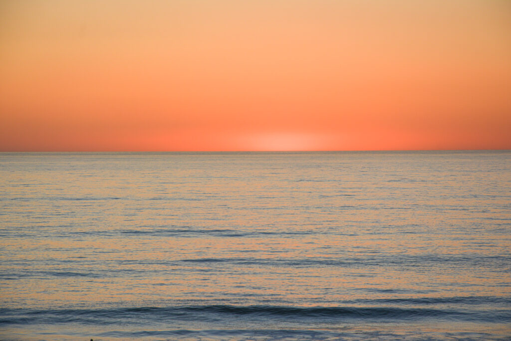 vivid orange ocean fire sunset horizon calm water fine art seascape photography by Hadi Baradaran ArtQuestor